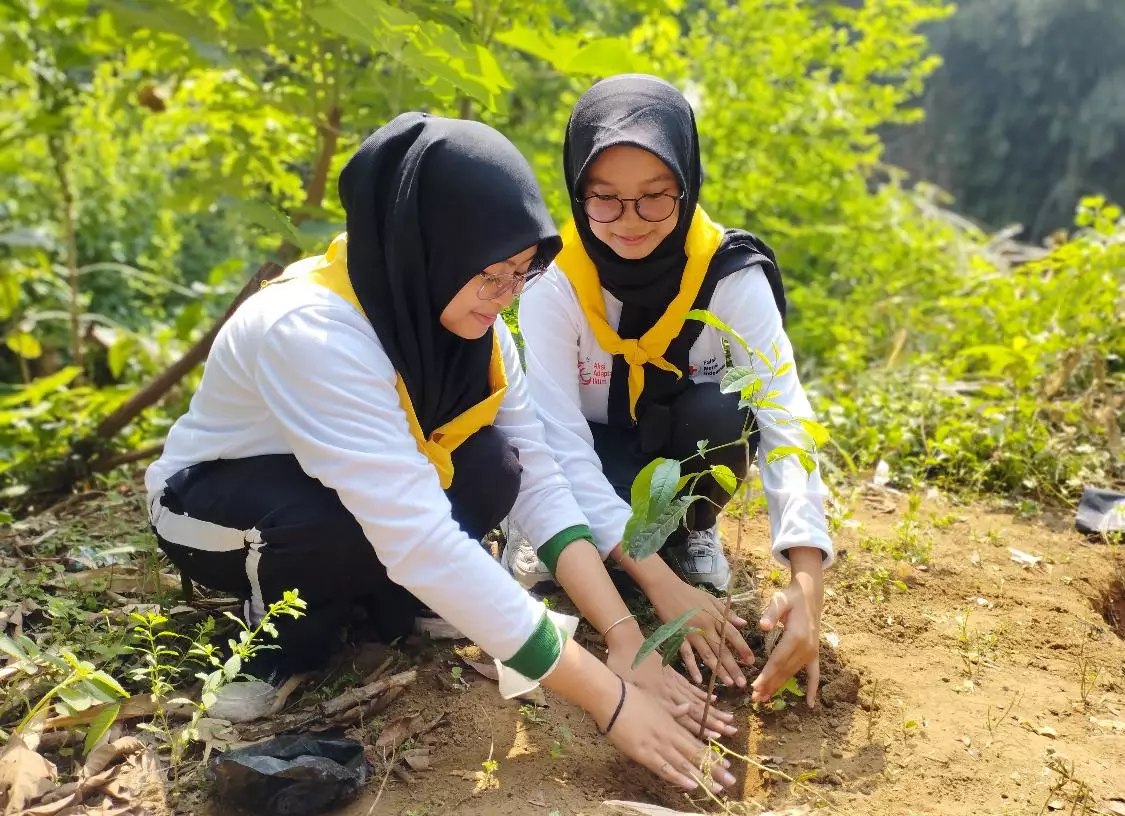 Aksi tanam pohon yang dilakukan Palang Merah Remaja (PMR) saat kegiatan Peringatan HUT Ke-79 PMI Tingkat Kota Depok di bantaran Sungai Ciliwung. (Istimewa)
