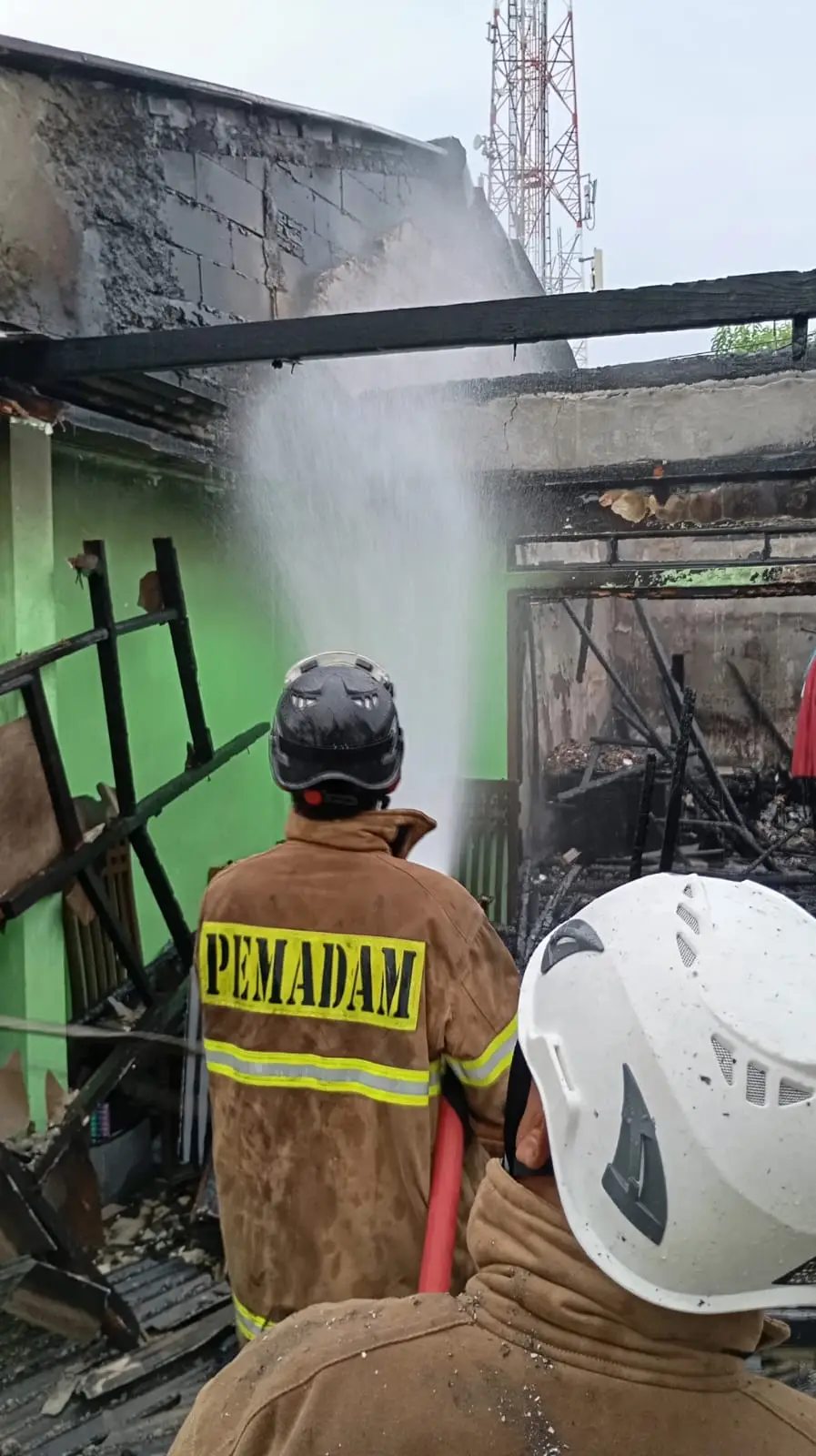 Petugas Dinas Damkar saat memadamkan api yang membakar rumah warga di Kelurahan Rangkapan Jaya Baru (Istimewa)